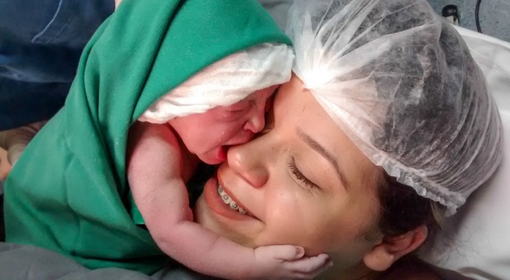 After birth, a baby girl clings to her mother's face ... so sweet!
