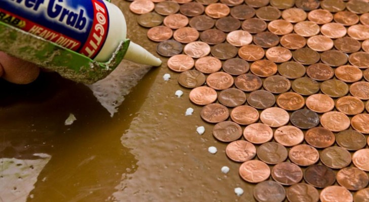 A woman uses 3 bags of pennies to transform the floorboards of a small, abandoned room