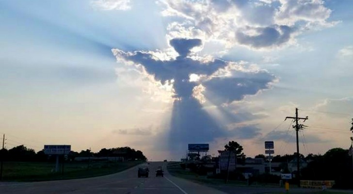 Un hombre aferra de inmediato el celular cuando ve un Angel entre las nubes en medio de la calle