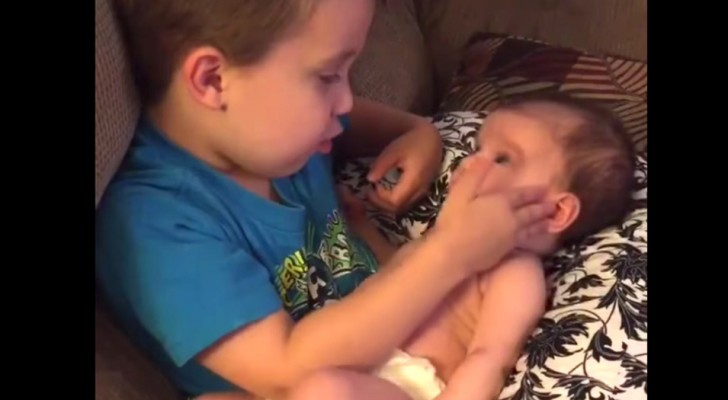 A little boy asks to hold his newborn sister in his arms as he tenderly sings her a song