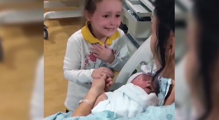Das kleine Mädchen sieht ihre neugeborene Schwester zum ersten Mal und weint wegen ihrer starken Gefühle