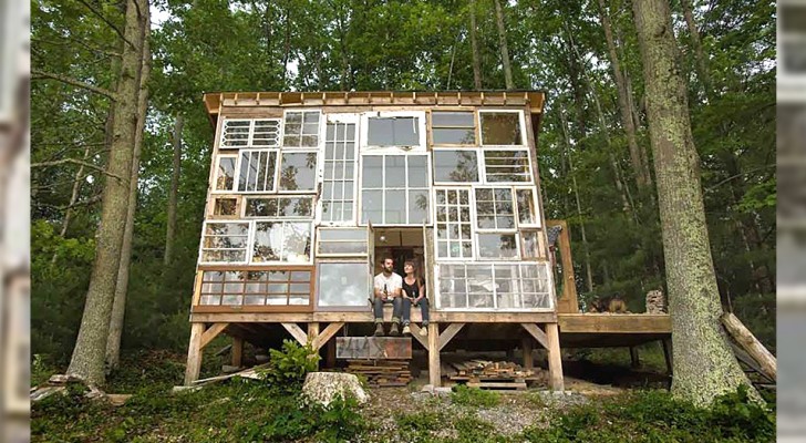 Un couple construit une maison dans les bois avec un mur fait de vieilles fenêtres recyclées