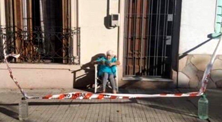 Sie möchte die Sonne genießen, ohne die Ausgangssperre zu missachten: Eine alte Dame richtet sich ihre Sicherheitszone vor der Haustür ein