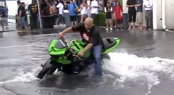 Um motociclista se diverte em uma grande poça: o show é extraordinário