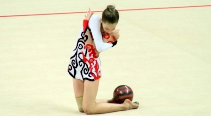 Met een rode bal voert ze een uitzonderlijke prestatie van ritmische gymnastiek uit