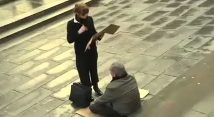 Una donna prende il cartello di un senzatetto: ciò che fa lo lascia senza parole