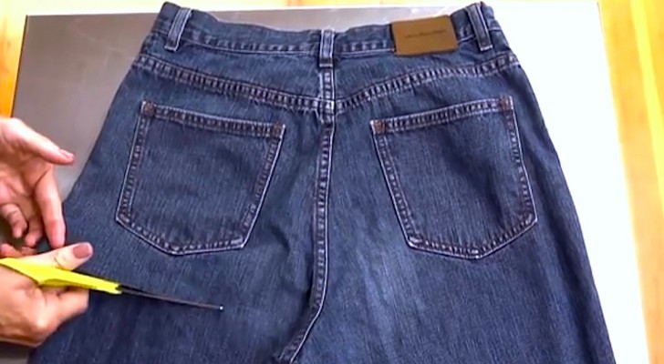 Una mujer corta un viejo par de jeans: lo que esta por crear es verdad