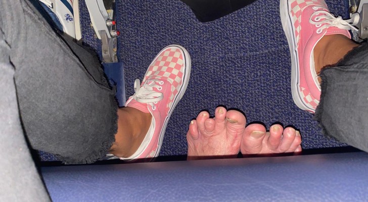 On an airplane, the passenger seated behind her stretches his bare feet under the seat, invading her personal space