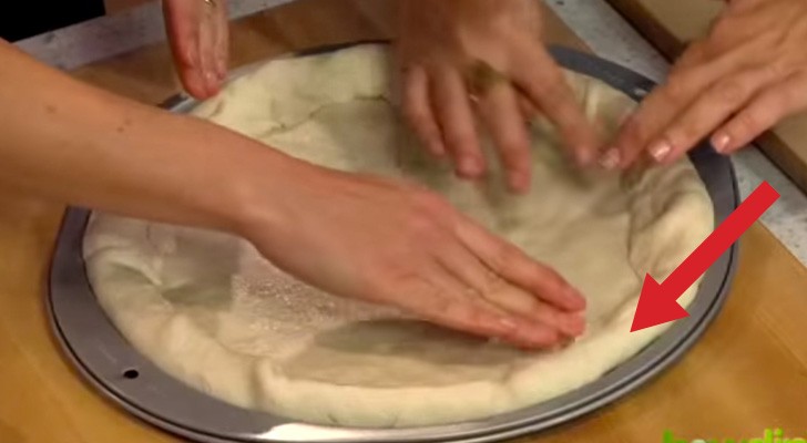 Elle met un ingrédient supplémentaire sous le bord de la pizza. Résultat: exquis!