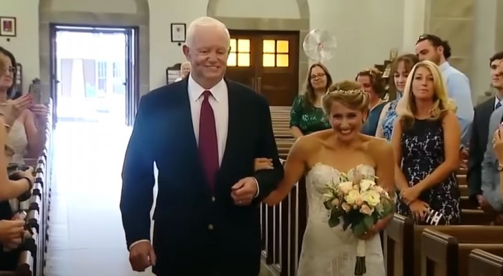 La sposa si emoziona quando l'uomo che ha ricevuto il cuore del suo defunto papà la accompagna all'altare