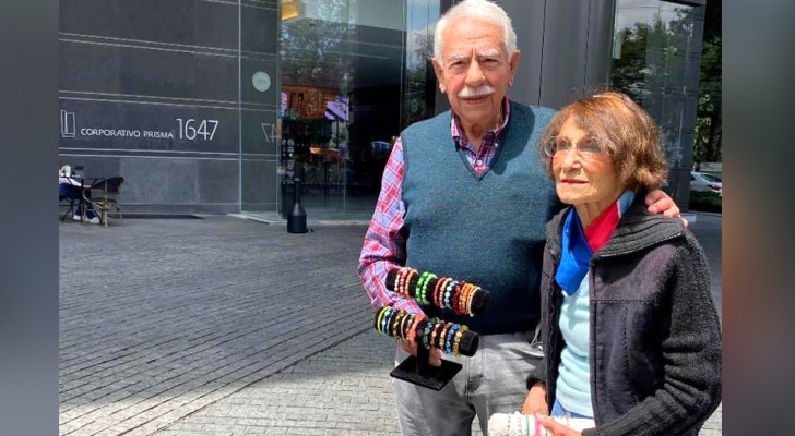 Un couple de personnes âgées photographié en train de vendre des bracelets faits main dans la rue : 
