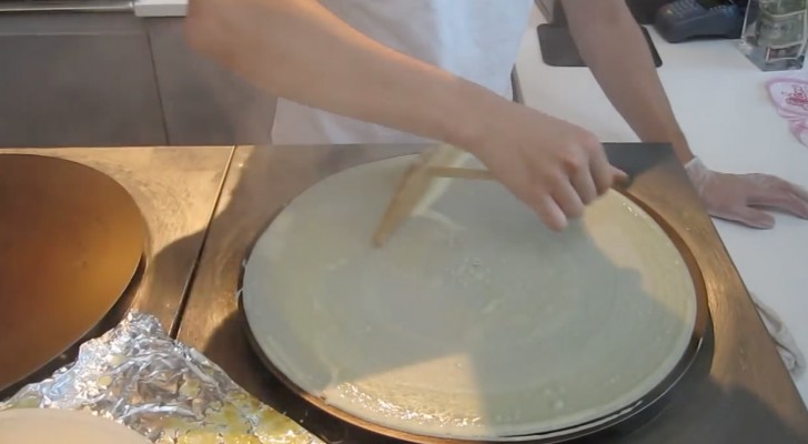 Hon sätter pannkaksdegen på den heta värmeplattan: efter någon minut kommer det att vattnas i munnen på er!