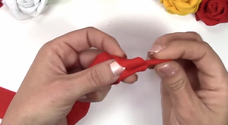 She cuts and rolls a strip of fabric: the final creation ... looks incredibly real!