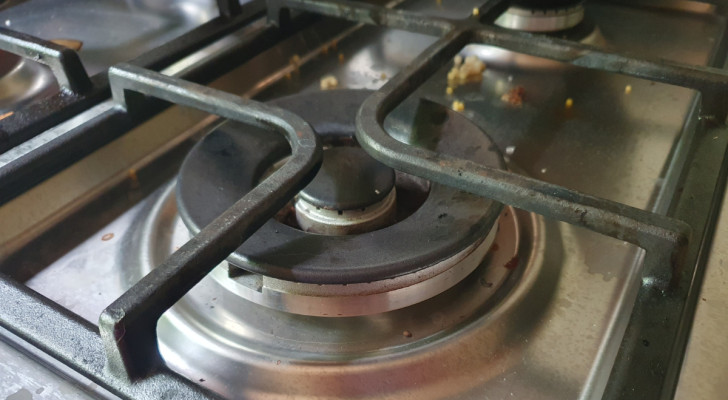 closeup of dirty gas stove grates