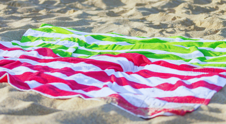 deux serviettes de plage colorées étendues sur le sable