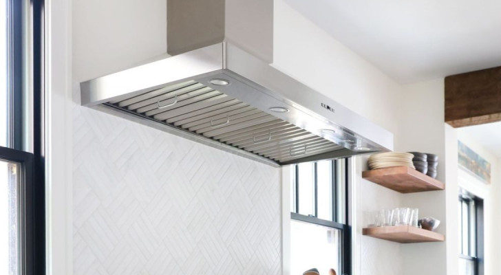 A stainless steel extractor hood above a kitchen oven