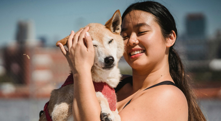 Una donna sorridente tiene in braccio un cane