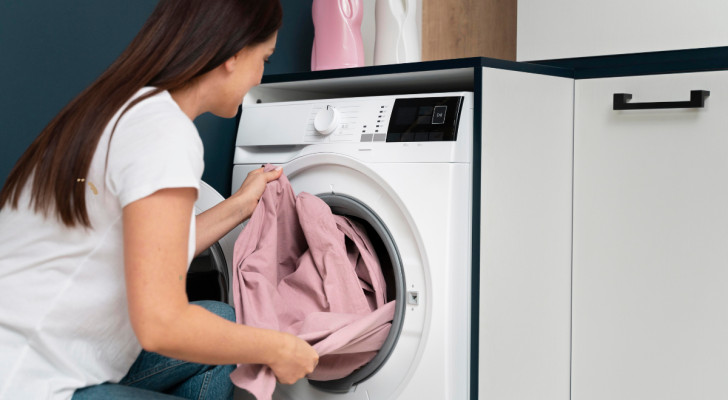 a woman pulling clothing from a washing machine