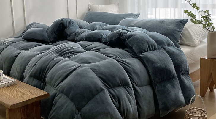 A person prepares to sleep in a bed with a weighted blanket