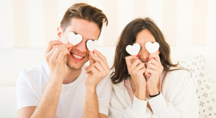 Un homme et une femme se cachent les yeux avec de petits cœurs blancs
