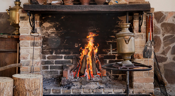 a lit fireplace with sooty bricks