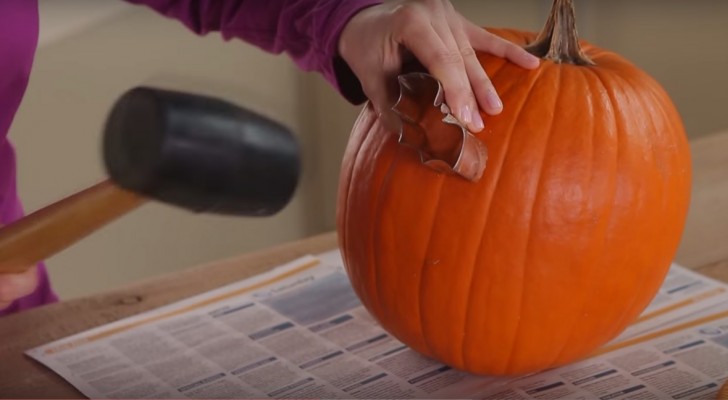 Sie benutzt einen Ausstecher auf einem Kürbis: Eine super Idee für Halloween!
