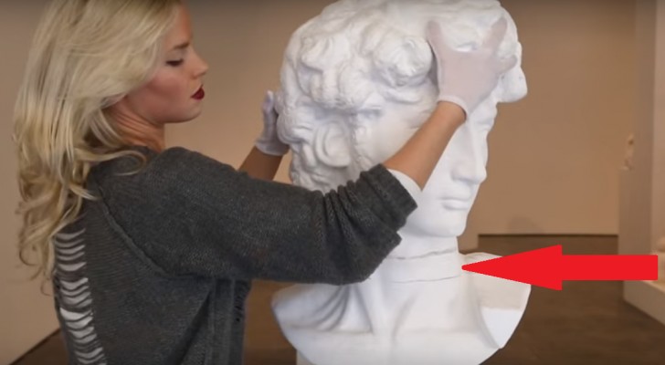 Sie legt die Hände auf eine berühmte Statue. Schaut mal, was mit dem Hals passiert 
