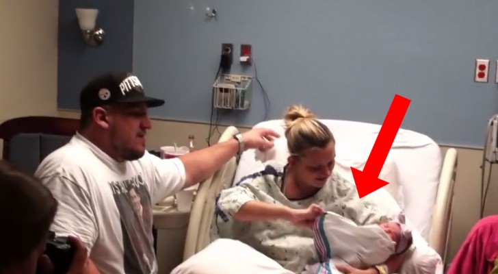 He picks up his newborn daughter --- But look at what lies under the baby's blanket ... Wow!