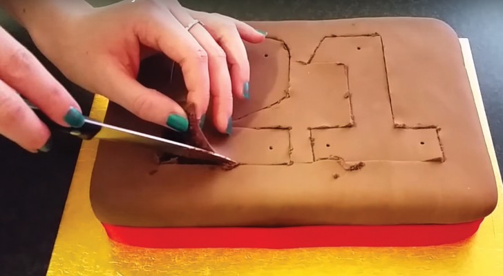 Ze begint een chocoladetaart in te snijden: deze manier van taart decoreren is origineel en verleidelijk voor de kinderen! 