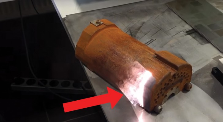 Um laser atinge um pedaço de metal enferrujado. O efeito é lindo de ver!